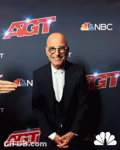 A Man In A Suit Stands In Front Of A Nbc Ad GIF