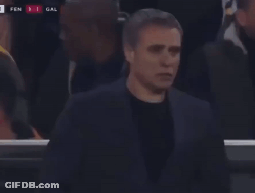 A Man In A Suit Stands In Front Of A Scoreboard That Says Fen 1 Gal On It GIF