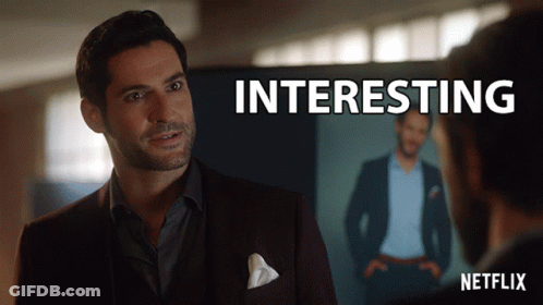 A Man In A Suit Stands In Front Of A Screen That Says " Interesting " GIF