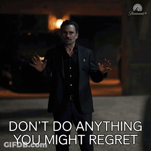 A Man In A Suit Stands In Front Of A Sign That Says " Don 'T Do Anything You Might Regret " GIF