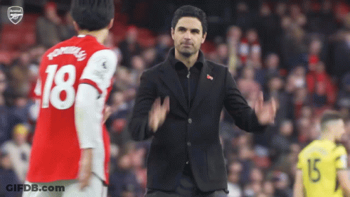 A Man In A Suit Stands In Front Of A Soccer Player With The Number 18 On His Jersey GIF