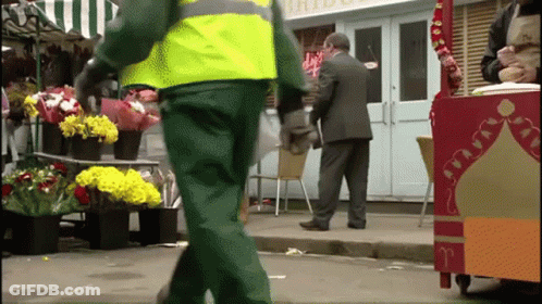 A Man In A Suit Stands In Front Of A Store That Has The Word Bride On It GIF