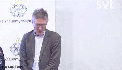 A Man In A Suit Stands In Front Of A Wall That Says Folkhälsomyndigheten GIF