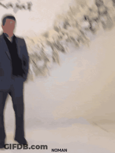 A Man In A Suit Stands In Front Of A Wall That Says Rita & Rajat GIF