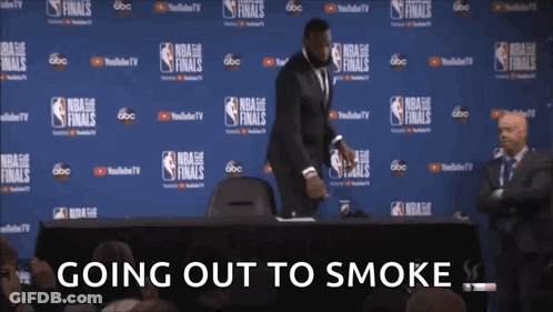 A Man In A Suit Stands In Front Of A Wall With Nba Finals Written On It GIF