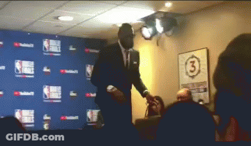A Man In A Suit Stands In Front Of A Wall With The Number 3 GIF