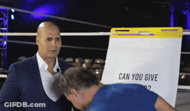 A Man In A Suit Stands In Front Of A White Board That Says Can You Give GIF