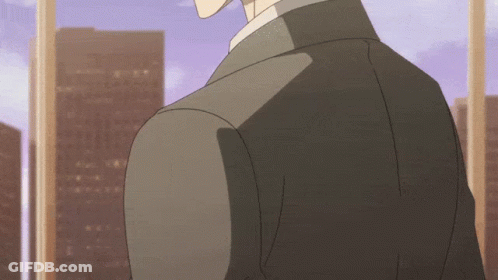 A Man In A Suit Stands In Front Of A Window With A City In The Background GIF