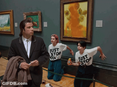 A Man In A Suit Stands In Front Of Two Girls Wearing Just Stop Oil T-Shirts GIF