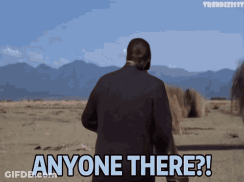 A Man In A Suit Stands In The Desert And Says Anyone There GIF