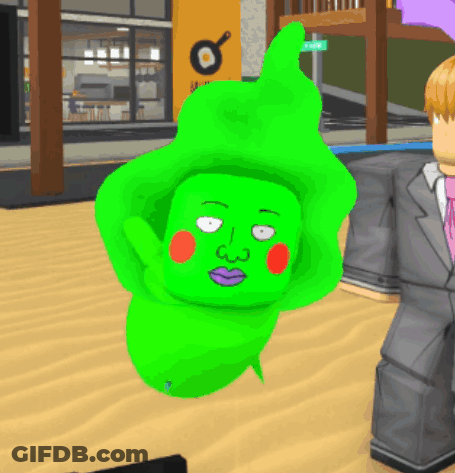 A Man In A Suit Stands Next To A Green Character GIF