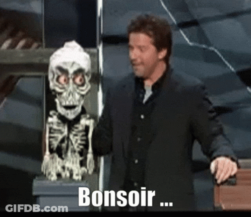 A Man In A Suit Stands Next To A Skeleton Statue And Says Bonsoir .. GIF