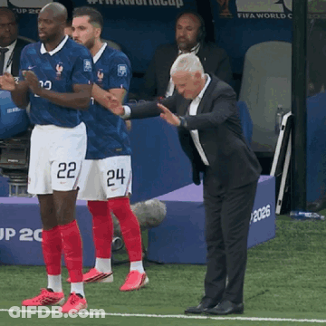 A Man In A Suit Stands Next To Two Soccer Players Wearing Shorts That Say 22 And 24 GIF