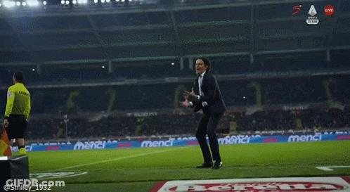 A Man In A Suit Stands On A Soccer Field GIF