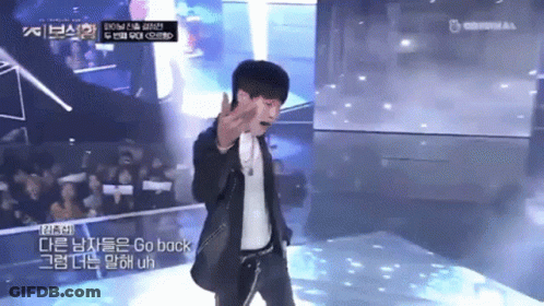 A Man In A Suit Stands On A Stage With A Microphone And Says Go Back GIF