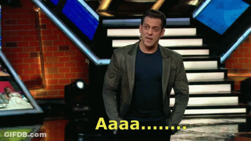 A Man In A Suit Stands On A Stage With The Word Aaa Behind Him GIF