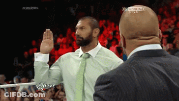 A Man In A Suit Takes A Oath In Front Of A Crowd On A Wrestling Show GIF