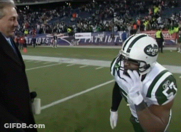 A Man In A Suit Talks To A Football Player Wearing A Jets Jersey GIF
