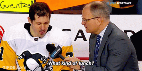 A Man In A Suit Talks To A Hockey Player Who Is Wearing A Jersey With The Number 1 On It GIF