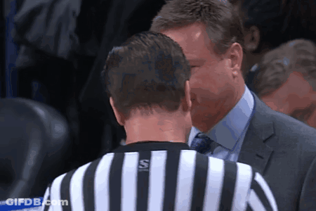 A Man In A Suit Talks To A Referee Who Is Wearing A Striped Shirt With The Letter S On It GIF