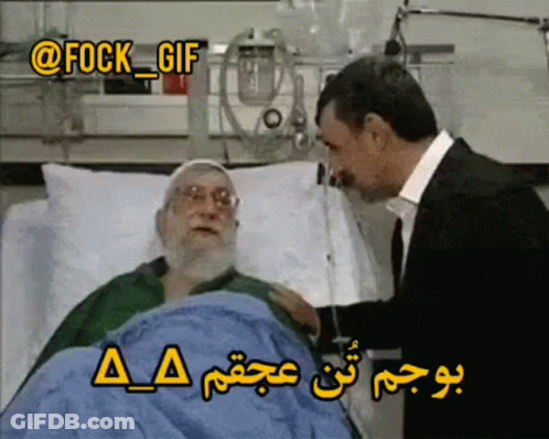 A Man In A Suit Talks To An Elderly Man In A Hospital Bed GIF