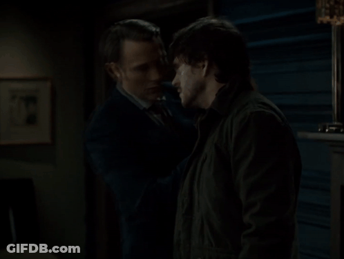 A Man In A Suit Touches Another Man 'S Face GIF