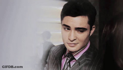 A Man In A Suit With A Pink Shirt And Tie Looks At The Camera GIF