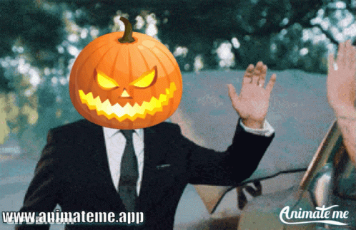 A Man In A Suit With A Pumpkin On His Head Is Waving GIF