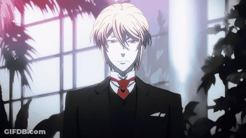 A Man In A Suit With A Red Tie Stands In Front Of A Window GIF