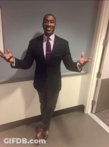 A Man In A Suit With His Arms Outstretched GIF