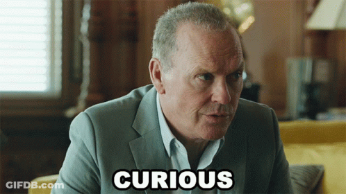 A Man In A Suit With The Word Curious Written On His Face GIF
