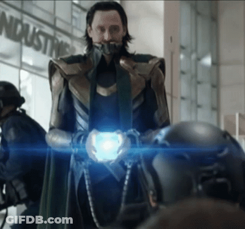 A Man In A Superhero Costume Holds A Blue Object In Front Of A Sign That Says Industry GIF