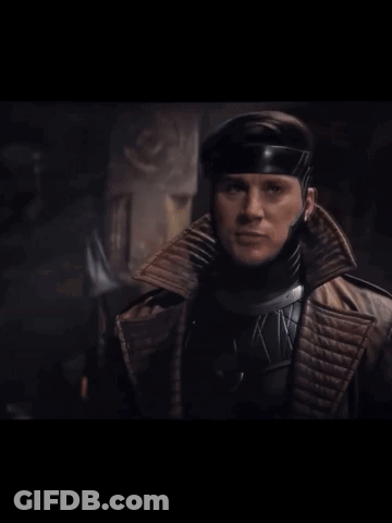 A Man In A Superhero Costume Holds A Purple Card GIF