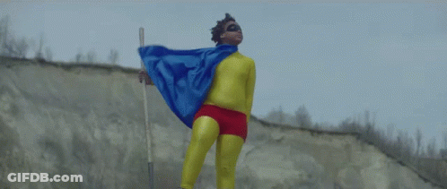 A Man In A Superhero Costume Holds A Stick GIF