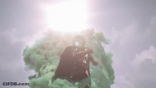 A Man In A Superhero Costume Is Flying Through A Cloud Of Green Smoke GIF