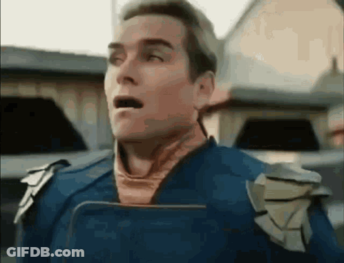 A Man In A Superhero Costume Is Holding A Book In His Hand And Making A Surprised Face . GIF