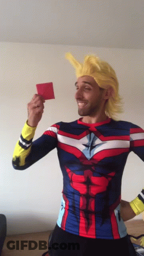 A Man In A Superhero Costume Is Holding Up A Red Card GIF