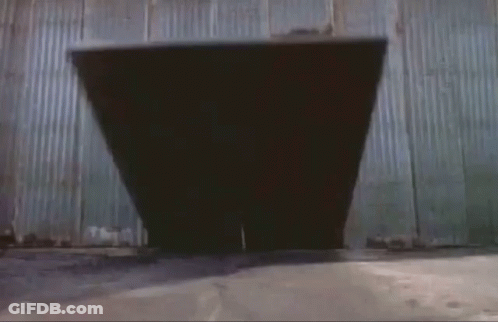 A Man In A Superhero Costume Is Jumping Through A Doorway GIF