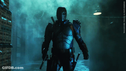 A Man In A Superhero Costume Is Standing In A Dark Room With A Sign That Says Tm & 2010 Wbei GIF