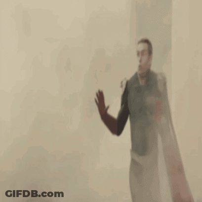 A Man In A Superhero Costume Is Standing In Front Of A Banner GIF