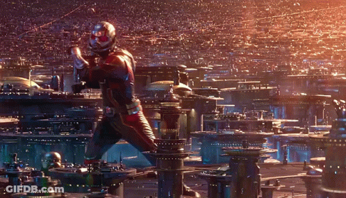 Man In Superhero Costume Standing In Front Of City GIF