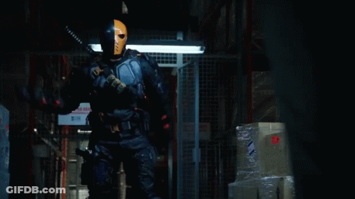 A Man In A Superhero Costume Is Standing In Front Of A Sign That Says " No Smoking " GIF