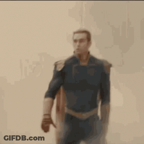 A Man In A Superhero Costume Is Walking Through A Cloud Of Smoke . GIF