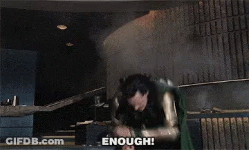 A Man In A Superhero Costume Says " Enough " In Front Of Him GIF