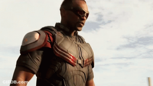 A Man In A Superhero Costume Stands In Front Of A White Sky GIF