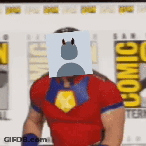 A Man In A Superhero Costume With A Card On His Face . GIF