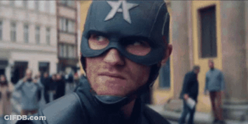 A Man In A Superhero Costume With A Star On His Helmet Is Looking At The Camera . GIF