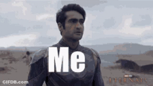 A Man In A Superhero Suit Is Standing In The Desert With The Words `` Me '' Written On His Chest . GIF
