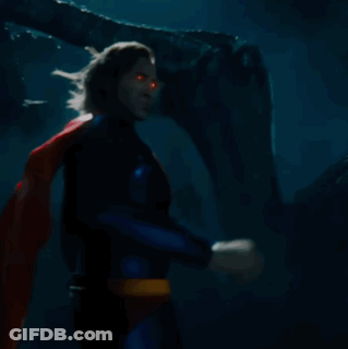 A Man In A Superman Costume Has A Red And Yellow S On His Chest GIF