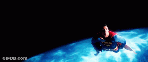 A Man In A Superman Costume Is Flying Over A Body Of Water GIF